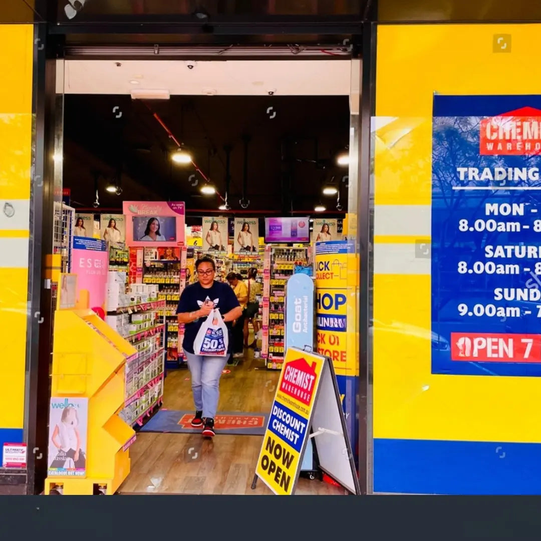 man coming out of Chemist Warehouse carrying a plastic bag