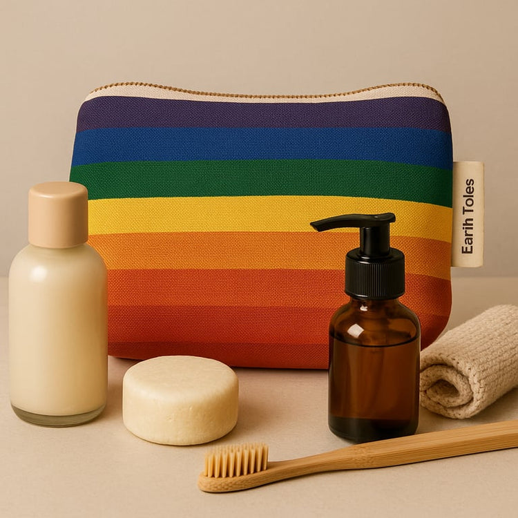 Earth Totes rainbow makeup organic cotton pouch surrounded by cosmetic products.
