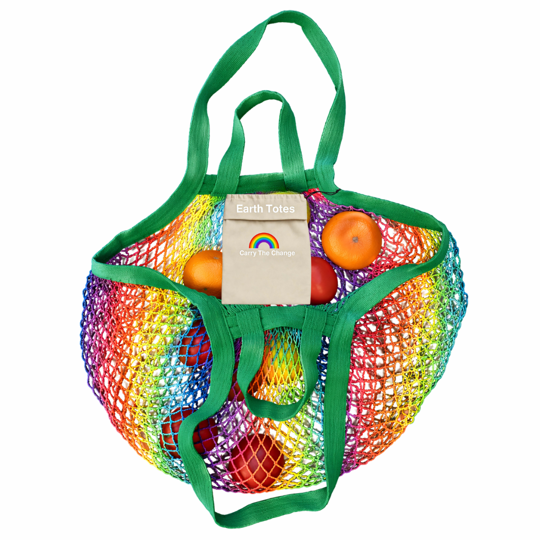 Multicolored mesh bag with green handles containing fruits and a card, on a white background.